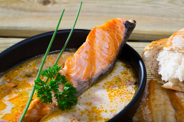 istock Delicious cream  soup with salmon, served  in bowl with bread at table 1276539991