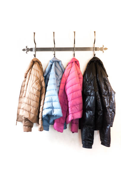 istock Four Colorful Puffy Winter Jackets Hanging on Rack 1276542207