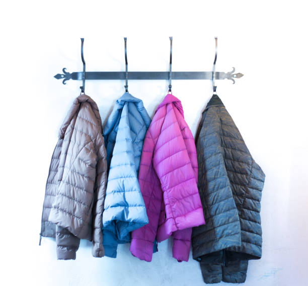 istock Four Colorful Puffy Winter Jackets Hanging on Rack 1276542212