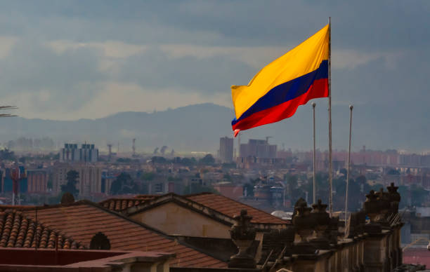 bandiera colombiana con vista sulla città di bogotà - colombiano foto e immagini stock