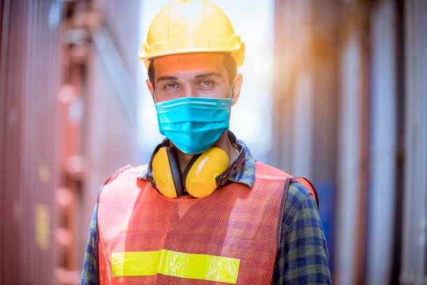 istock Portrait man dock worker under inspection and checking production process on dock station with radio communication by wearing safety mask to protect for pollution and virus in factory 1276548357