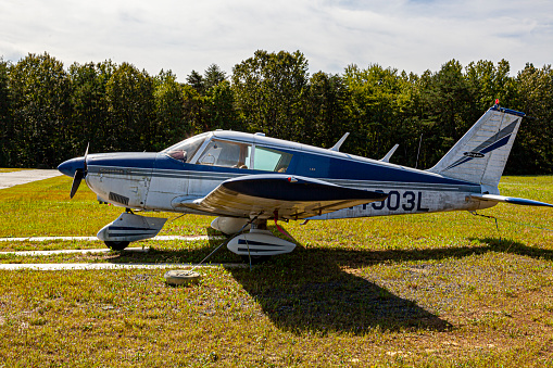 Indian Head, MD, USA 09/19/2020: Side view of an old single engine propeller aircraft  (Piper Cherokee PA 28) parked on the lawn at Maryland Airport (2W5).