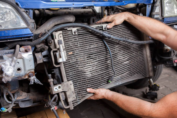 Disassembly of an old and worn car radiator by a mechanic Disassembly of an old and worn car radiator by a mechanic condenser stock pictures, royalty-free photos & images
