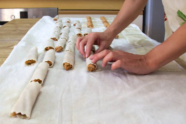 Woman making cannelloni in her kitchen. Home cooking concept.