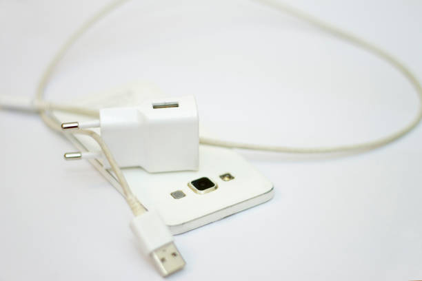 Modern white smartphone and phone charge with power cord isolated on the white background