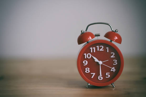 istock Red alarm clock on a wood table 1276564130