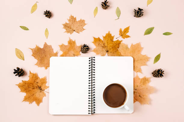 istock Autumn flat lay with dry leaves, notebook, pine cone and coffee cup on pastel beige studio background with copy space for advertisement. Thanksgiving, fall, halloween concept. Creative composition 1276566499
