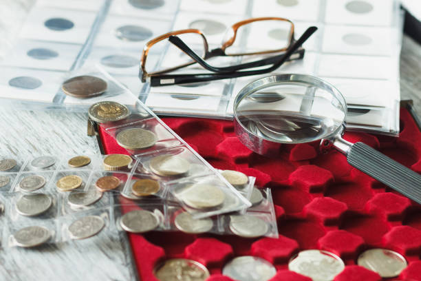 istock Different collector's coins with a magnifying glass and glasses 1276567469