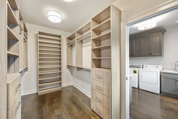 Amazingly efficient shelving in walk-in closet Walk-in closet with hardwood flooring connecting to laundry room walk in closet stock pictures, royalty-free photos & images