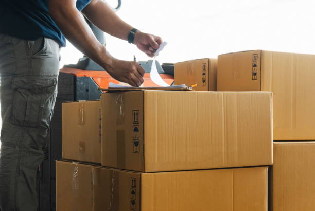 istock Worker writing on clipboard his doing inventory management product boxes on pallet. Checking stock, Shipment, packaging. 1276568398