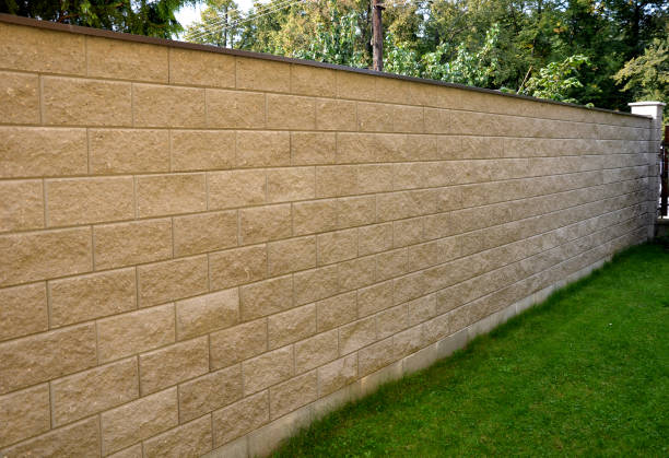 recinzione muro in gesso alto in capannone di blocchi di cemento prefabbricato con cemento e filo d'acciaio con tetto in metallo sul prato superiore parco giardino grigio colore beige ruvida trama - precast foto e immagini stock