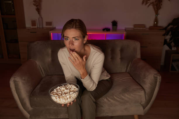 istock Woman eating popcorn 1276569641