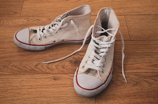 old white sneakers on the wooden floor