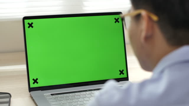Businessman looking at green screen computer