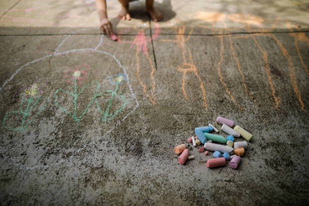 istock Shallow depth of field (selective focus) image with colored chalk for children on a concrete pavement. 1276571528