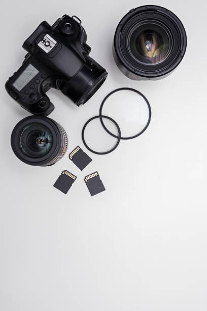 istock dslr camera, lenses, photo equipment and copy space over white table 1276573953