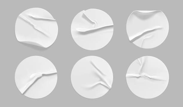 istock White round crumpled sticker mock up set. Adhesive white paper or plastic sticker label with glued, wrinkled effect on gray background. Blank templates of a label or price tags. 3d realistic vector 1276575121