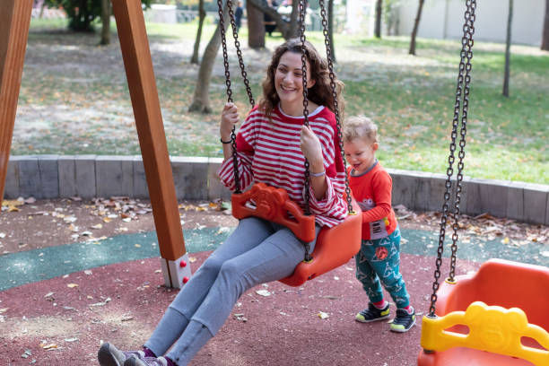 istock Son Swinging his Mother on a Swing 1276576221