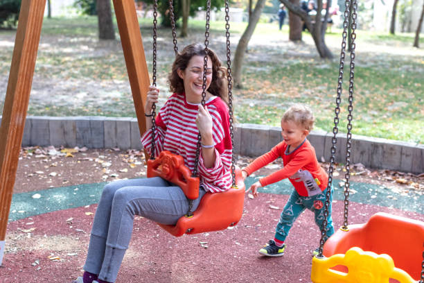 istock Son Swinging his Mother on a Swing 1276576587