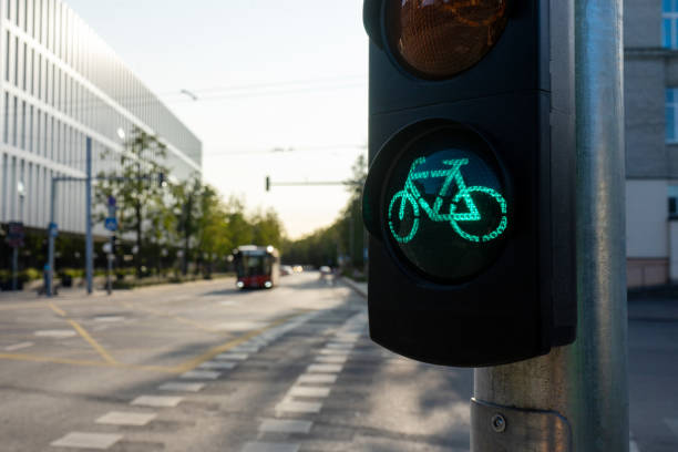 semáforos para bicicletas em um dia ensolarado de verão com vista desfocada da cidade em um fundo. - bicycle sign symbol bicycle lane - fotografias e filmes do acervo