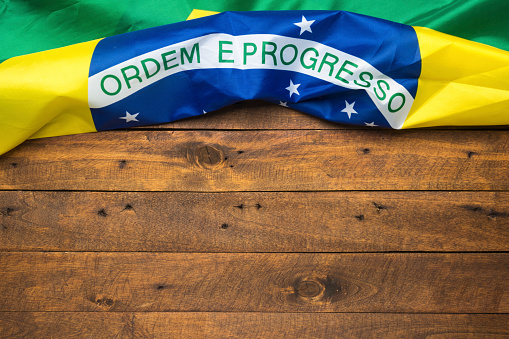 Brazilian flag lying on old wooden background