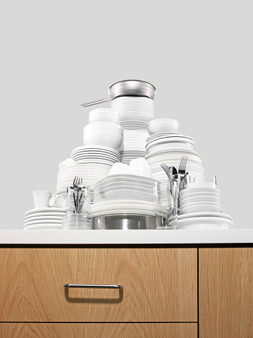 Modern tableware set with cutlery and a vibrant blue plate, with glasses, overhead flat lay shot. Trendy dinnerware on a white marble background