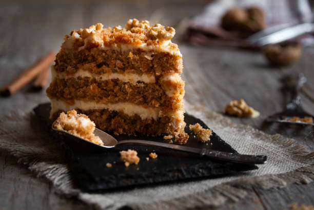 istock Piece of cake. Carrots and walnuts cake with creamy cheese 1276579964