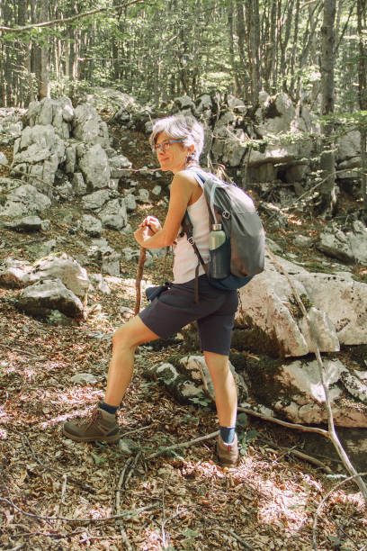 istock Middle age woman takes rest during hiking in mountains 1276582140