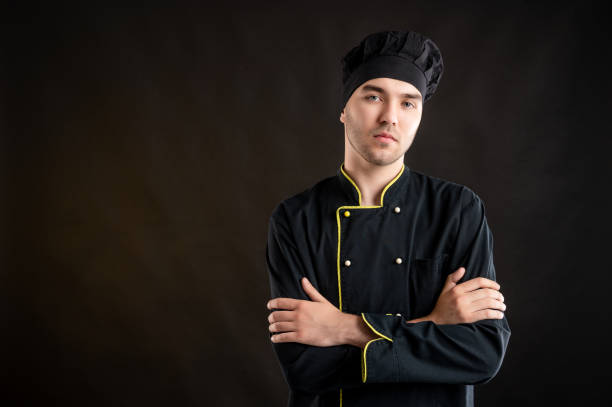 istock Young male dressed in a black chef suit looking confident 1276584498