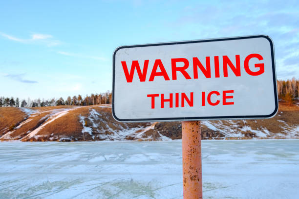 istock thin ice warning sign, pond and hills background 1276584902
