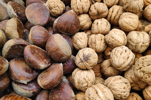 Stack of chestnuts and walnuts on a merchant's stall.