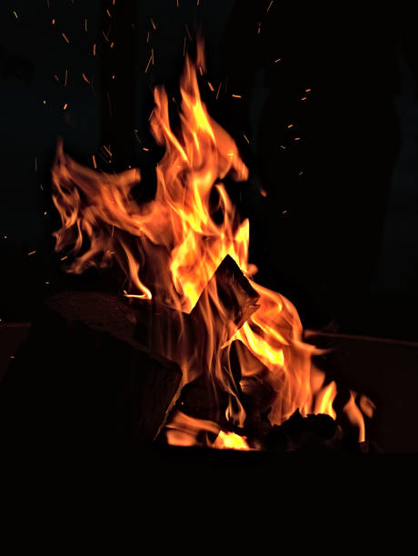 brennendes holz vor schwarzem hintergrund - fire pit fire camping burning stock-fotos und bilder