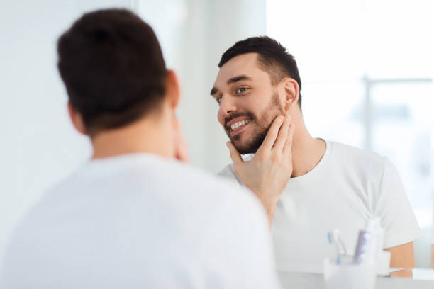 istock happy young man looking to mirror at home bathroom 1276590852