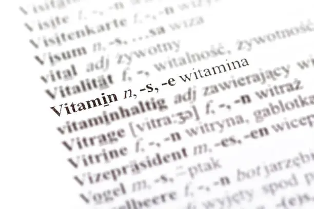 Photo of Word vitamin - witamina in a Polish - German dictionary line pointed out, selective focus, macro, closeup, detail Medicine supplementation, immunity foreign language medical translation