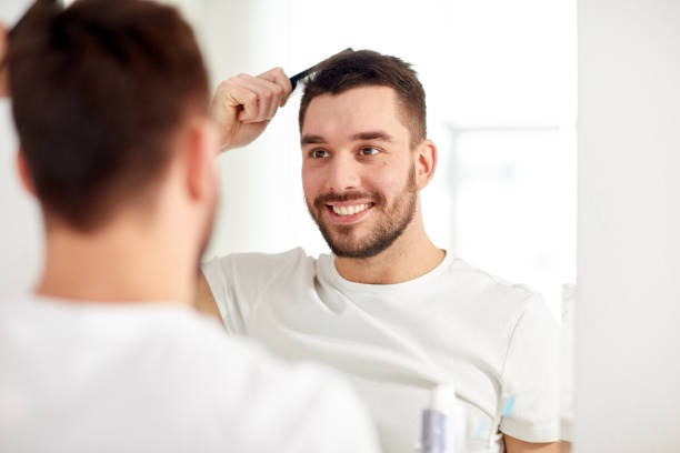 istock happy man brushing hair  with comb at bathroom 1276591776