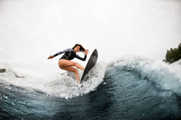 istock young sportive woman masterfully ride surf board on the wave 1276593964