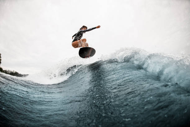 istock young active woman surfs coolly on surf board and jumps on the wave 1276594046