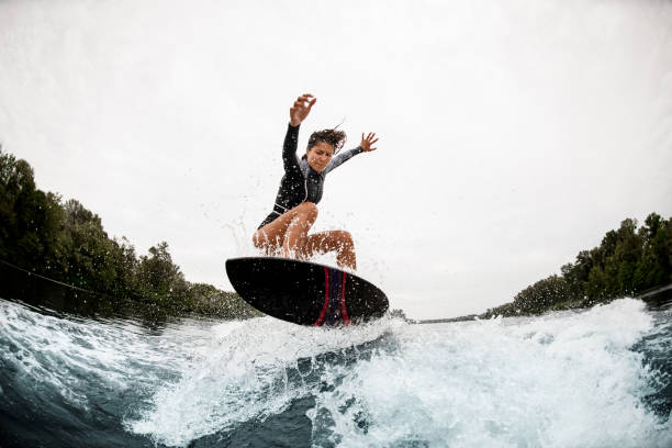 istock sportive woman masterfully jump on the wave 1276594066
