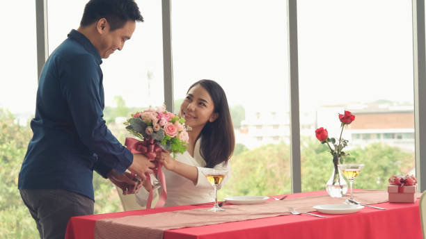 istock Romantic couple giving gift to lover at restaurant 1276594203