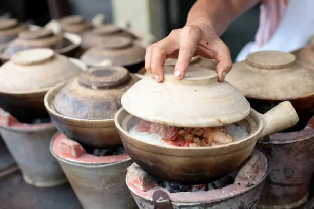 A sneak peek on claypot chicken rice cooking in progress at business stall in Kuala Lumpur, Malaysia.
