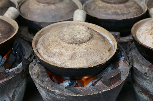 A focus scene on cooking claypot chicken rice at his business stall in Kuala Lumpur, Malaysia.