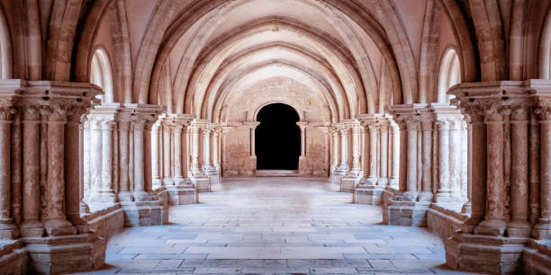 sonnenbeschienener gotischer korridor kathedrale innenhof. wallpaper - church indoors inside of monastery stock-fotos und bilder