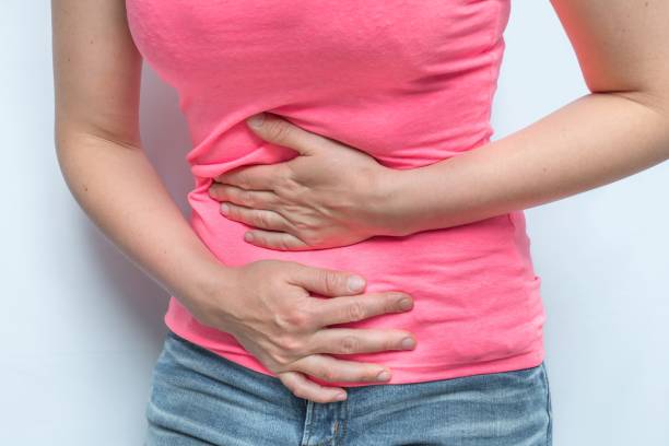 istock Woman with menstrual pain is holding her aching belly 1276601331