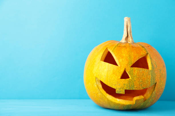 istock Halloween pumpkin head jack lantern on blue background 1276604893