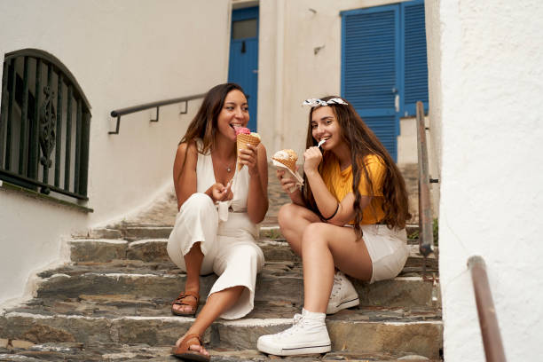 istock Two sisters having ice cream together outdoors. 1276605794