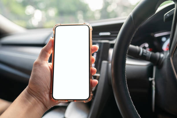 istock Image of hand holding mobile phone with mockup white screen in car. 1276605834