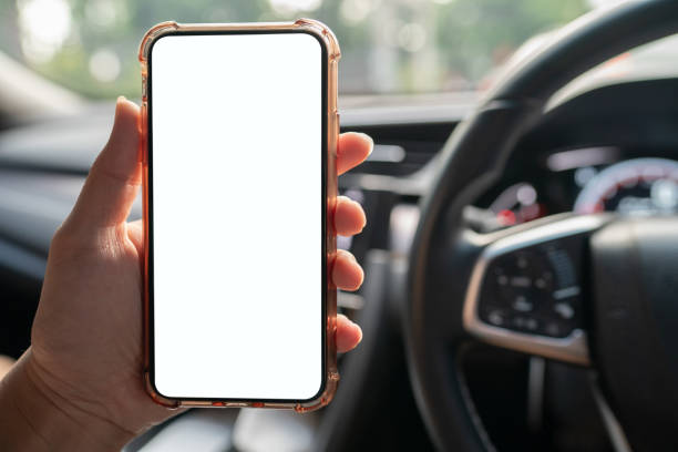 istock Image of hand holding mobile phone with mockup white screen in car. 1276605895
