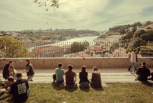 Porto, Portugal: Many people meeting and having fun on hill over river Douro, with scenic city view on 19 May, 2019. Portuguese language has 250 million total speakers