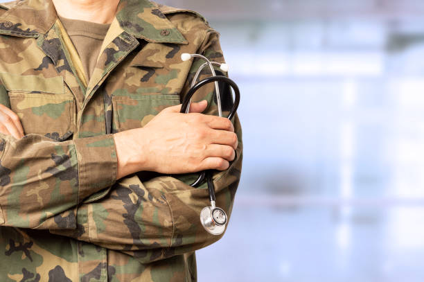 military doctor with crossed arms at a hospital Cropped shot of an unrecognizable male military doctor standing with his arms folded inside of a hospital during the day military uniform stock pictures, royalty-free photos & images