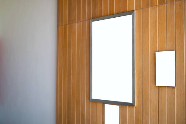 istock Mock up blank poster frame hanging on wooden wall in room. 1276609904
